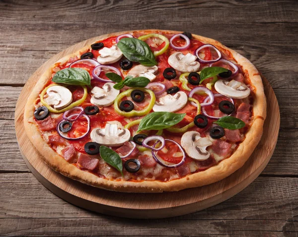 Italian delicious pizza with mushrooms and ham on the old boards — Stock Photo, Image