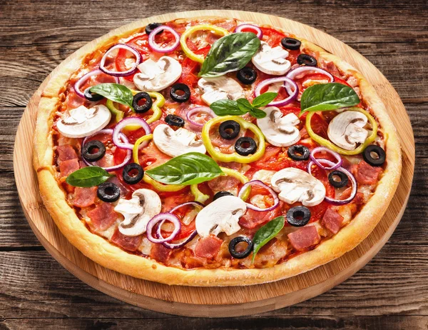 Italian delicious pizza with mushrooms and ham on the old boards — Stock Photo, Image