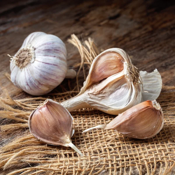 Rustic style. Garlic and denim on old boards. — Stock Photo, Image