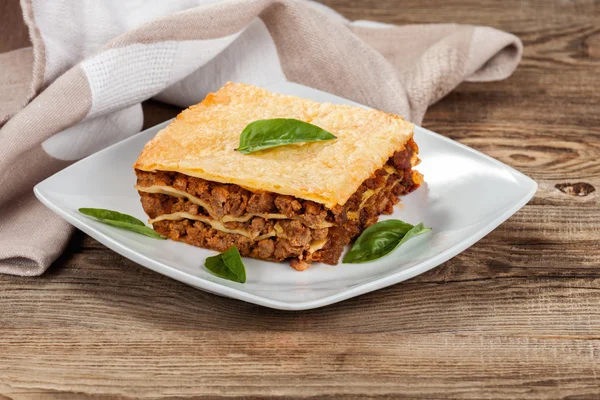 Fresh hot lasagna on old boards — Stock Photo, Image