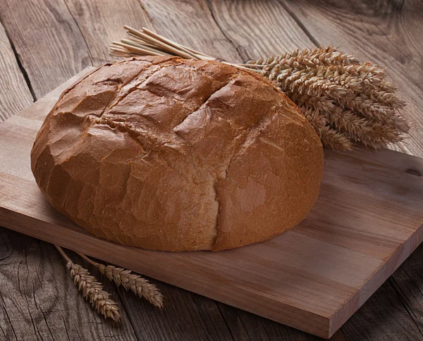 Bread and ears on the old boards — Stock Photo, Image