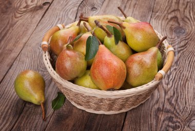 Eski bir masada bir sepet armut.