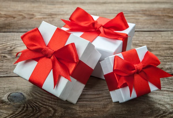 White box with a red bow on old boards — Φωτογραφία Αρχείου