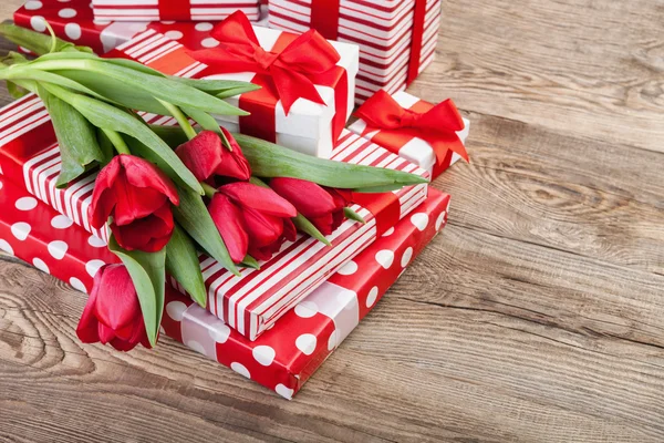 Boîtes avec rubans blancs et un bouquet de tulipes — Photo