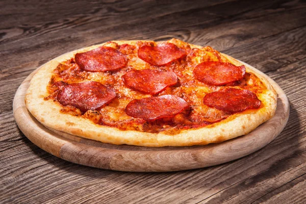 Pizza with salami on the old board — Stock Photo, Image