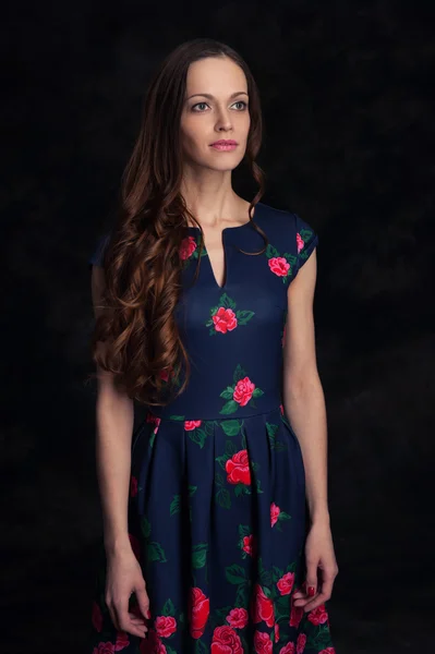 Schöne junge Frau in einem Kleid mit lockigen langen Haaren — Stockfoto