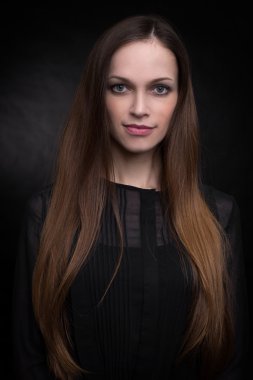 Karanlık bir arka planda güzel genç bir kadın.