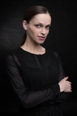 Karanlık bir arka planda güzel genç bir kadın.