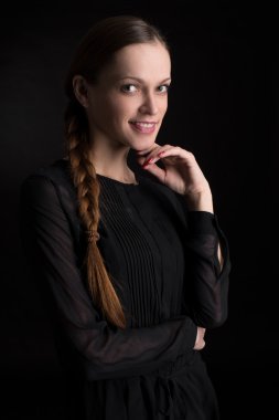 Karanlık bir arka planda güzel genç bir kadın.