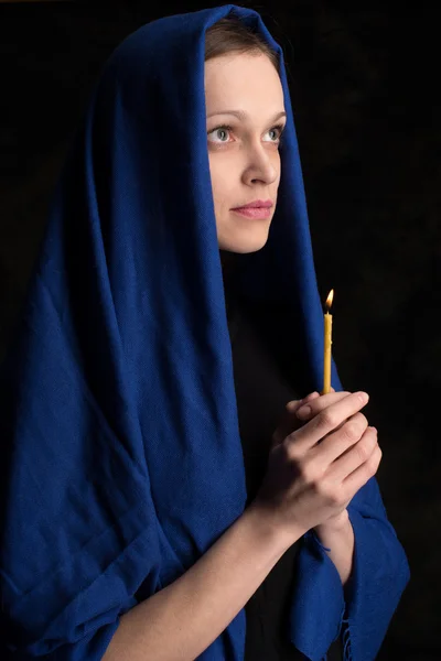 Vrouw bedrijf kaars en gebed — Stockfoto