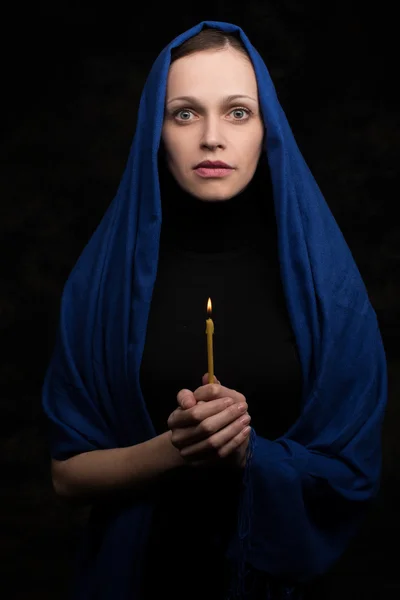 Donna che tiene la candela e prega — Foto Stock