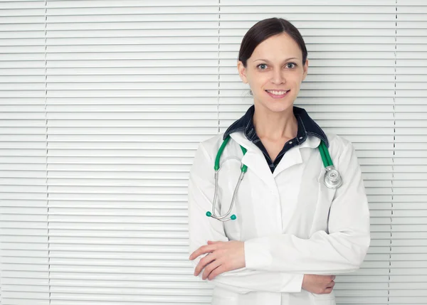 Medico donna sorridente con stetoscopio in carica — Foto Stock