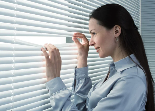 Ufficio lavoratore guardando attraverso tende da finestra — Foto Stock