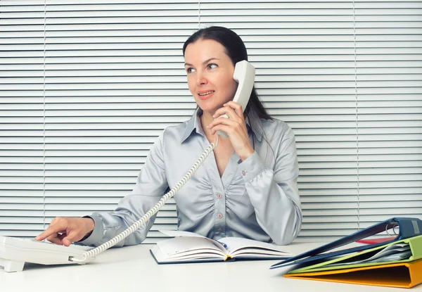 Podnikání žena sedí v kanceláři a mluví na telefonu — Stock fotografie