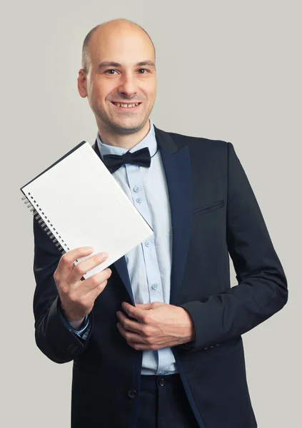 Elegante hombre de traje muestra una hoja en blanco — Foto de Stock