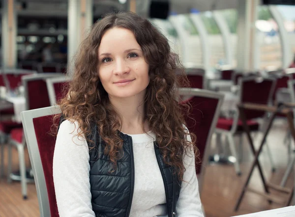 Menina bonita com cabelo encaracolado no café — Fotografia de Stock