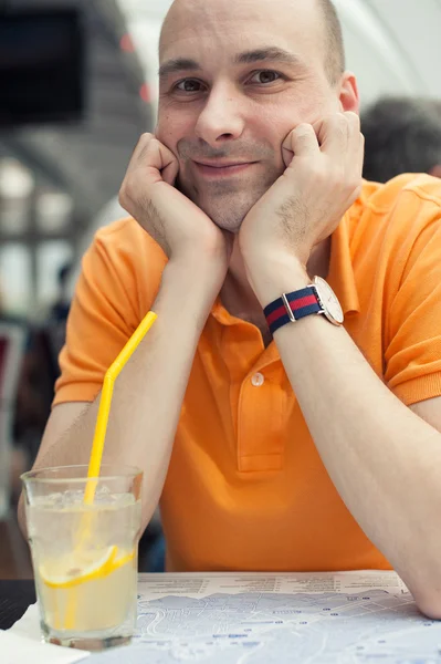 Smiling man sits in cafe — Stock Photo, Image