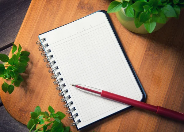 Caderno em branco em uma placa de corte — Fotografia de Stock