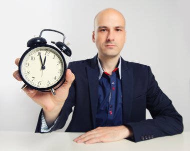 bir çalar saat gösterilen ciddi iş adamı