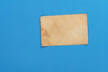 Mavi arka planda eski, yıpranmış sarı kağıt