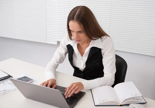 Affärskvinna med anteckningsboken i office — Stockfoto