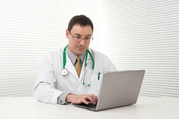 Médico usando seu computador portátil Imagem De Stock