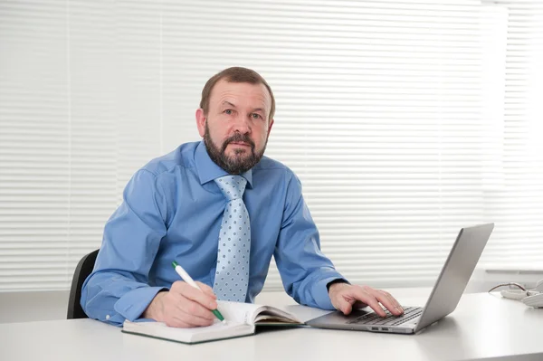 Зрілий бізнесмен працює на своєму ноутбуці — стокове фото