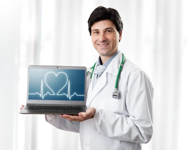 Beau docteur montrant ordinateur portable avec battement de coeur — Photo