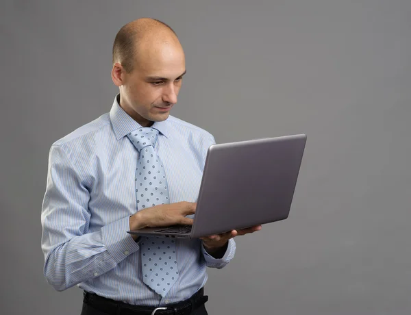 Homem de negócios bonito trabalhando no laptop — Fotografia de Stock