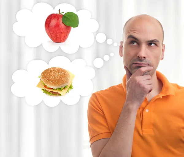 Man choosing between apple and sandwich — Stock Photo, Image