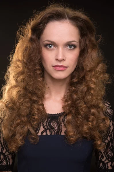 Schöne Frau mit langen braunen lockigen Haaren — Stockfoto
