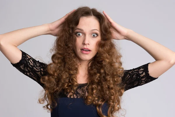 Surprised woman with long curly hair — Stock Photo, Image