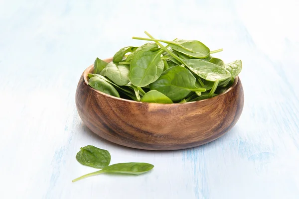 Spinach leaves in a wooden plate — Stock Photo, Image