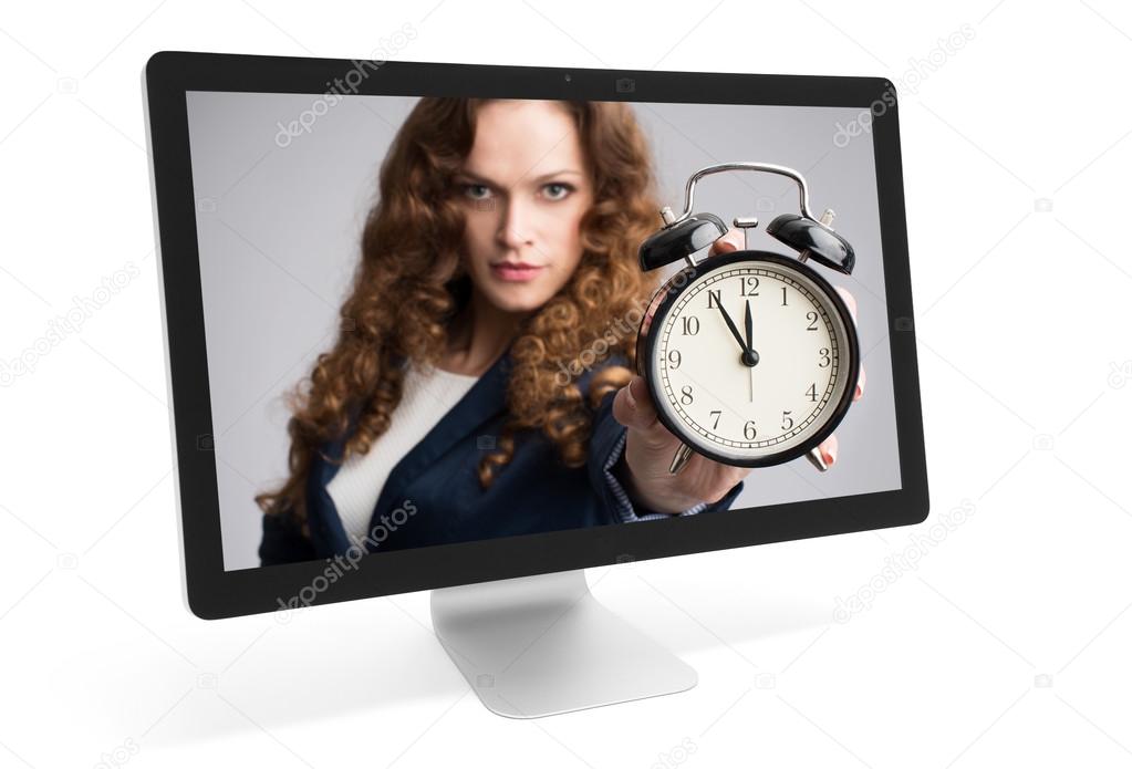 woman looking through monitor and showing alarm clock