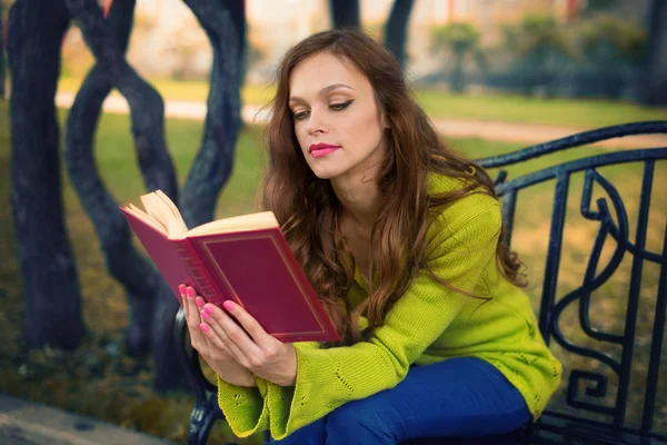 Jonge vrouw die boek leest in het park — Stockfoto