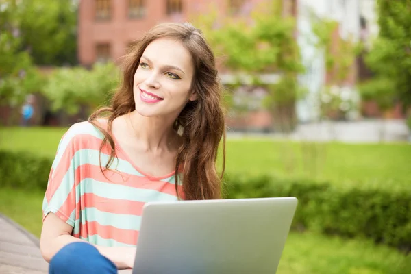 Gyönyörű nő használ egy laptop a szabadban — Stock Fotó