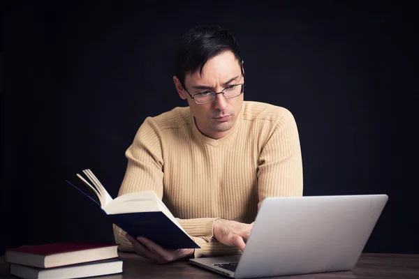 Man met laptop en boek — Stockfoto