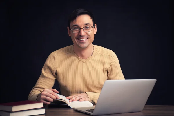 Sorrindo bonito homem lendo um livro — Fotografia de Stock