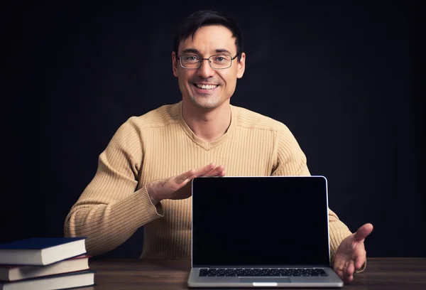 Zelfverzekerde jonge man reclame laptop — Stockfoto