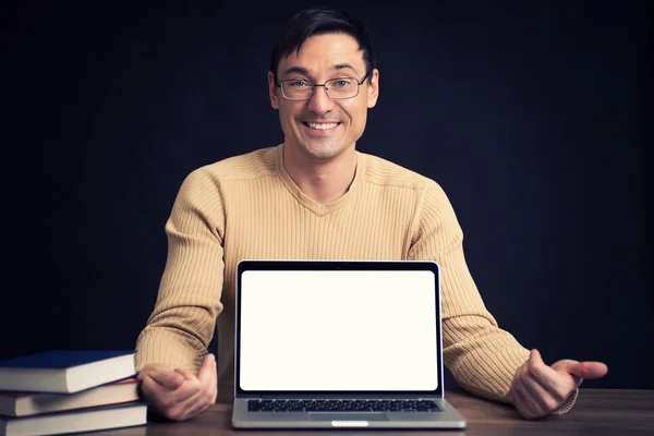 Confident young man advertising laptop — Stock Photo, Image