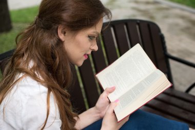 Parkta okuyan genç bir kadın.