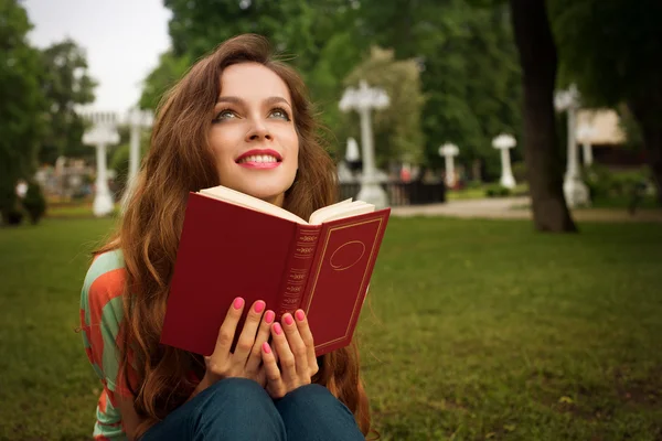 Vacker flicka med bok i parken — Stockfoto