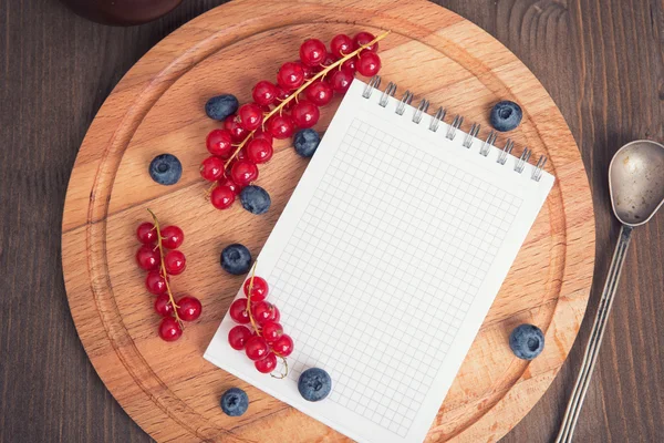 Red currant, blueberry and notepad — Zdjęcie stockowe