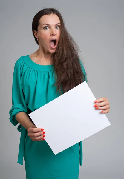 Mujer sorprendida sosteniendo cartel en blanco — Foto de Stock