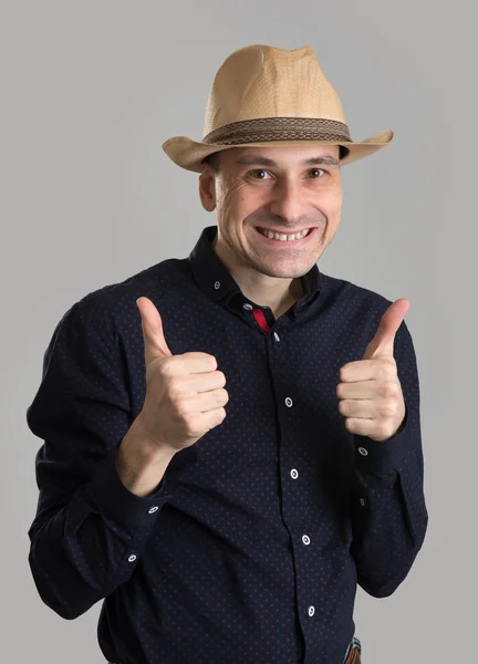 Χαμογελαστός άνθρωπος στο ψάθινο καπέλο τους αντίχειρές του εμφανίζονται — Φωτογραφία Αρχείου