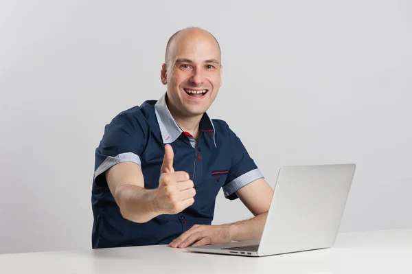 Bald man sits at the desk with laptop — Stock Photo, Image