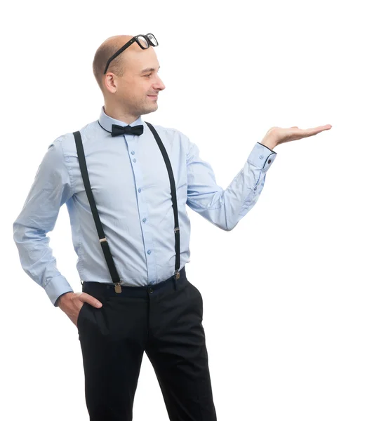 Homem vestindo gravata arco e suspensórios apresentando algo — Fotografia de Stock