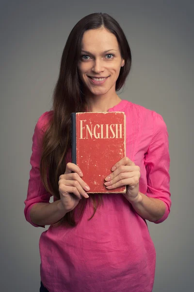 Mujer joven con libro de texto en inglés —  Fotos de Stock