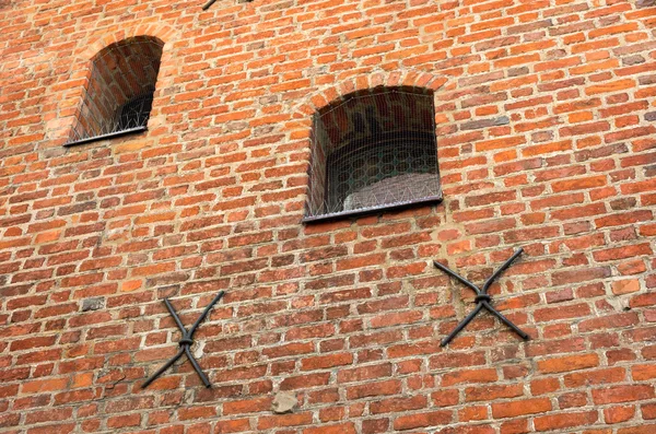 Pequeña ventana con barras en una vieja pared de ladrillo. Las barras de metal de la —  Fotos de Stock