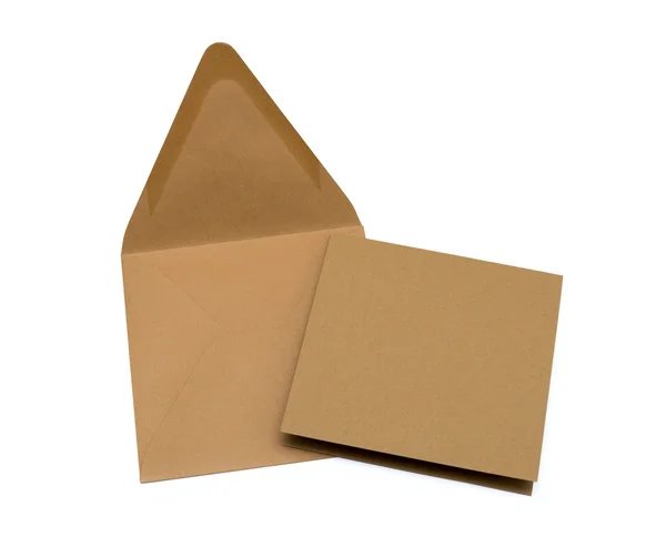 Brauner Umschlag mit einer leeren Karte über weißem Papier — Stockfoto